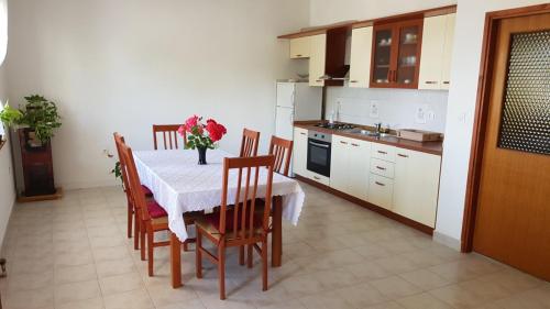 eine Küche mit einem Tisch und einer Blumenvase darauf in der Unterkunft Comfort apartment on the beach in Kali