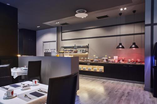 un restaurante con 2 mesas y una barra con cocina en Silken Coliseum, en Santander