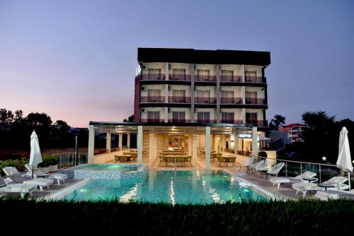 a hotel with a swimming pool in front of a building at Hotel Lion in Ulcinj