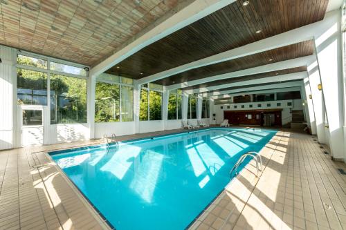 a swimming pool in a house with a large window at Garden & City Megève - Combloux in Combloux