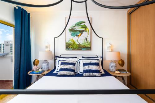 una camera da letto con un grande letto con tende blu di stylish apartment with marina view and aircon a Portimão