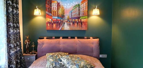 Un dormitorio con una cama y un cuadro en la pared. en Summer house, en Ventspils