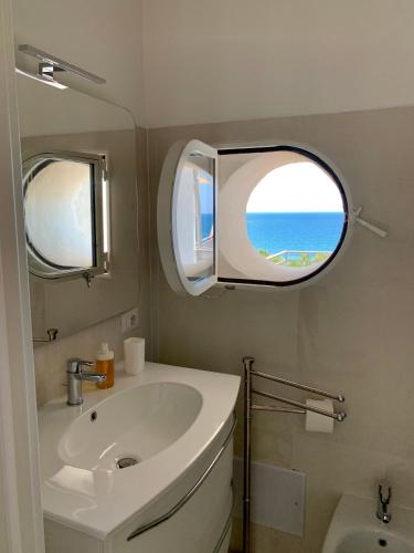 a bathroom with a sink and an oval window at VILLA MARIS in Agropoli
