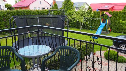 a patio with a table and chairs and a playground at Pokoje Żabi Staw in Mikołajki