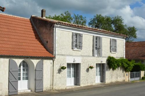 an old white building with an orange roof at Au Cœur de Ménestérol in Montpon-Ménestérol