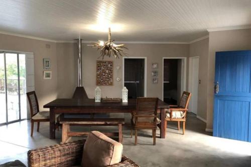 a living room with a dining room table and chairs at Staples House - Living The Breede in Malgas