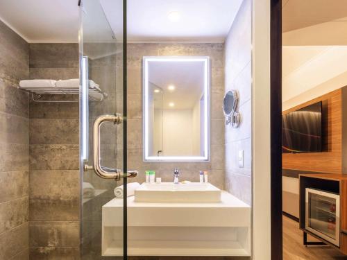 a bathroom with a sink and a shower at Novotel Santiago Providencia in Santiago