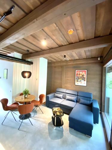 a living room with a blue couch and a table at Villa Gaida in Saulkrasti