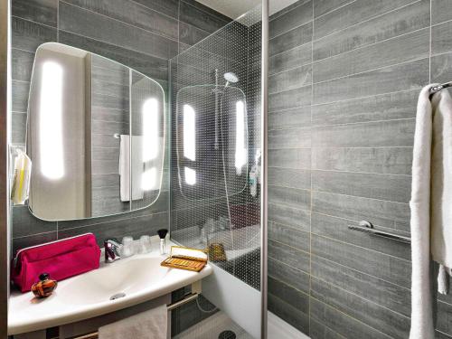 a bathroom with a sink and a mirror at ibis Macon Sud Crêches in Crêches-sur-Saône