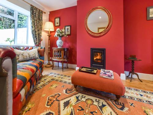 a living room with a couch and a mirror at Hyde Tyning Cottage in Minchinhampton
