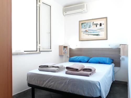 - une chambre avec un lit et des serviettes dans l'établissement Tortolì attico in centro a 5 minuti dal mare, à Tortolì