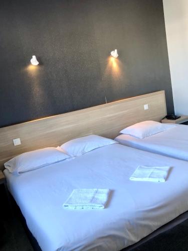 Dos camas en una habitación de hotel con dos toallas. en Hôtel le Bretagne et Restaurant Le Papillon en Gorron