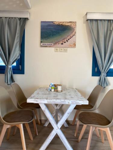 una mesa blanca con sillas y una foto de playa en Michail Suites Afiartis Karpathos, en Karpathos