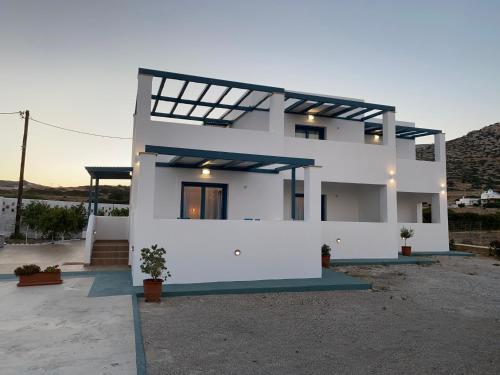 a white house with a sunset in the background at Michail Suites Afiartis Karpathos in Karpathos Town