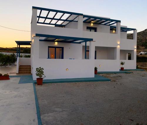 a white house with a sunset in the background at Michail Suites Afiartis Karpathos in Karpathos Town