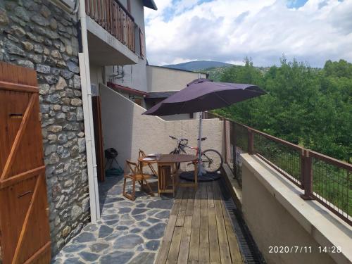 a table with an umbrella and a bicycle on a balcony at Apartamento Angostrina in Angoustrine