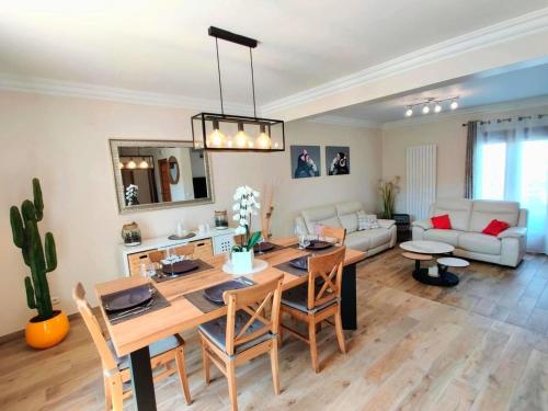 une salle à manger et un salon avec une table et des chaises dans l'établissement Maison 190m2 - Entre Paris et Disneyland, à Gagny