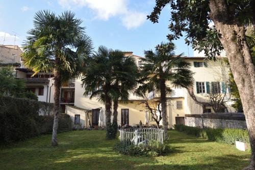 a white house with palm trees in the yard at Relais La Corte di Cloris in Florence