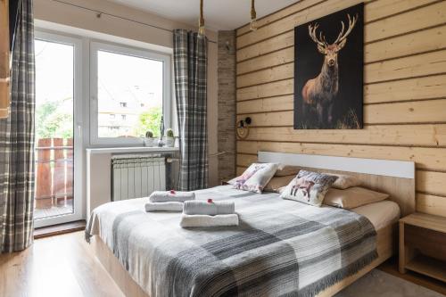 ザコパネにあるApartamenty Deja Vu Zakopaneのベッドルーム1室(鹿の絵が描かれたベッド1台付)