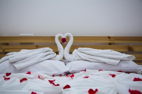 two white swans laying on top of a bed at Faza View Inn, Maafushi in Maafushi
