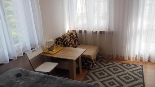 a small living room with a table and a chair at Pokoje Żabi Staw in Mikołajki