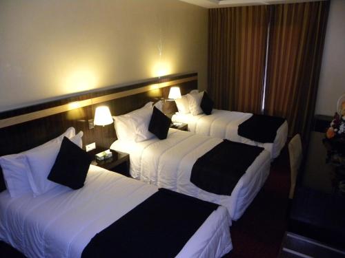 a hotel room with two beds with white and black sheets at Rive Hotel in Rabat