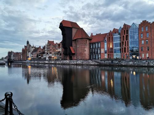 a city with buildings and a river with a building at Biała Perła Apartment in Gdańsk