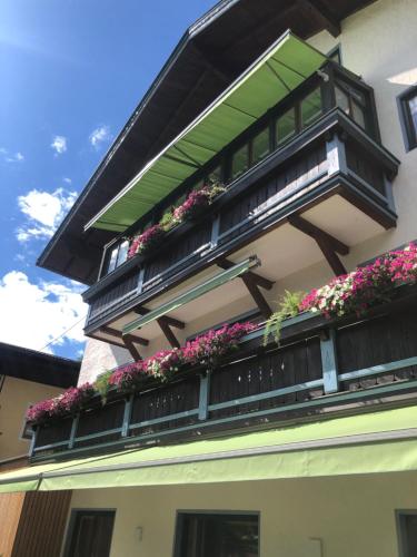 a balcony with flowers on the side of a building at Ferienwohnung am Bründlweg in Golling an der Salzach