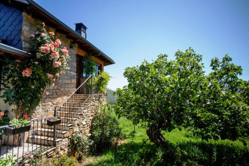 a stone house with a staircase and a tree at Rural Médulas Viviendas de uso turistico 2 y Casas rurales 2 in Las Médulas