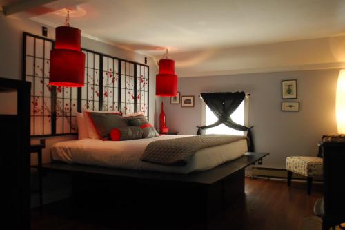 a bedroom with a bed with red lamps and a window at Admiral Peary Inn in Fryeburg