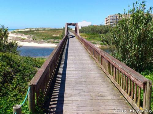 un puente de madera sobre una playa junto al océano en Apartamento Matosinhos Mar, en Matosinhos