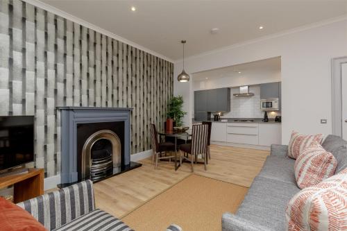 a living room with a couch and a fireplace at Destiny Scotland - Princes Street Residence in Edinburgh