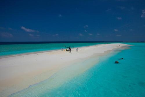 a group of people on a beach in the ocean at Kaani Village & Spa in Maafushi
