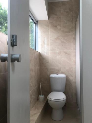 a bathroom with a white toilet and a window at ГотельОК Видубичі in Kyiv