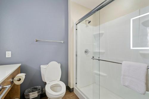 a bathroom with a toilet and a glass shower at Extended Stay America Premier Suites - Austin - Austin Airport in Austin
