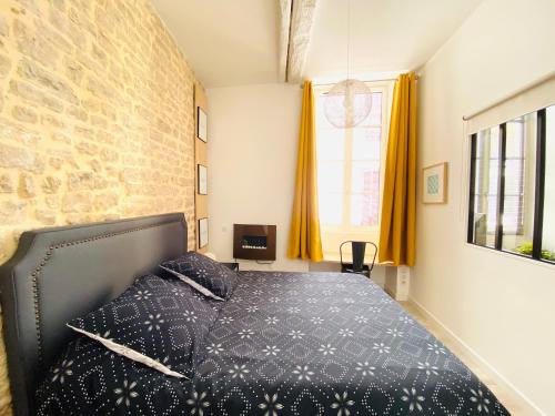 a bedroom with a bed and a brick wall at Feel@Home Nemausus « Le 4 » in Nîmes