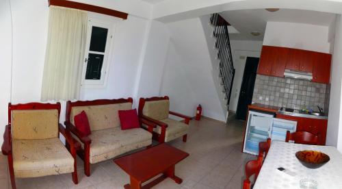 a living room with two couches and a table at Iriana Village Inn in Stavros