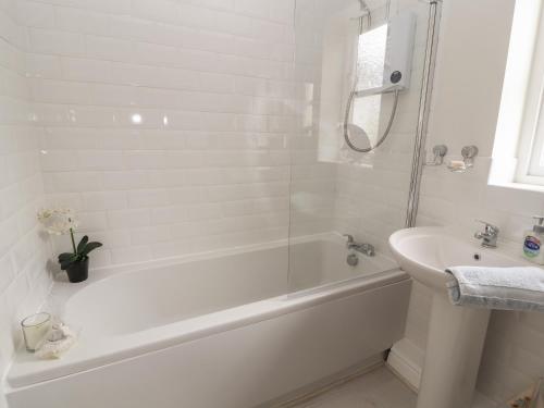 a white bathroom with a tub and a sink at Castle View in Conwy
