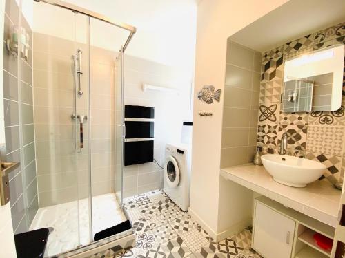 a bathroom with a shower and a sink and a washing machine at Feel@Home Nemausus « Le 4 » in Nîmes