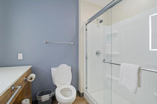 a bathroom with a toilet and a glass shower at Extended Stay America Premier Suites - Austin - Austin Airport in Austin