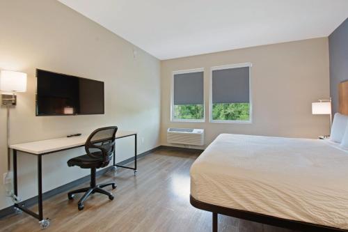 a hotel room with a bed and a desk and a television at Extended Stay America Premier Suites - Austin - Austin Airport in Austin