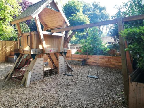 ein Baumhaus mit einer Leiter und Schaukeln in der Unterkunft Blesius Garten in Trier