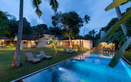Villa con piscina por la noche en STUTHI VILLA en Ahangama