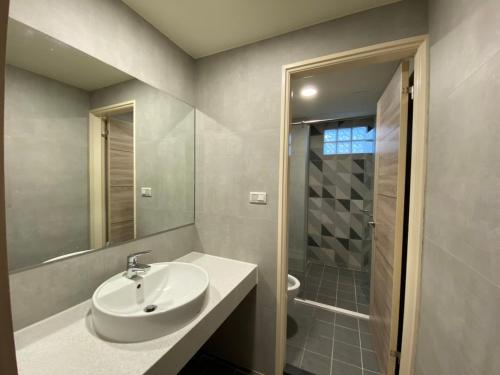 a white bathroom with a sink and a shower at IF Guest House in Tainan
