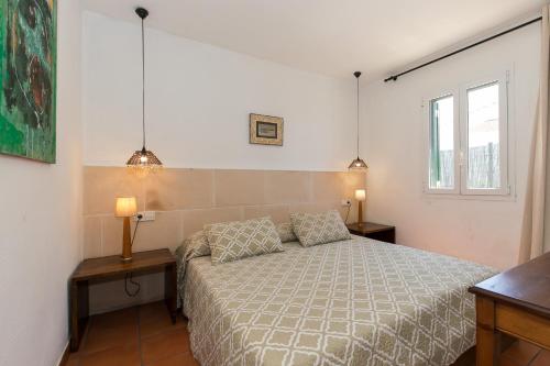 a bedroom with a bed with two tables and two lamps at Pura Vida in Binibeca