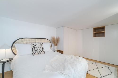 a white bedroom with a white bed and a table at Casa Boma Lisboa - Duplex Apartment In The Heart Of Lisbon - Arroios I in Lisbon