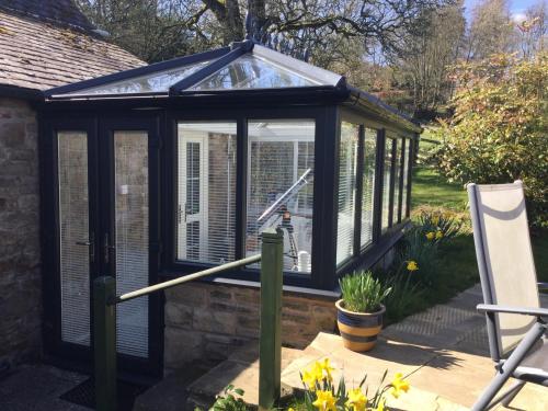 a greenhouse with a glass roof in a garden at The Snug @ Corry Cottage in Haltwhistle