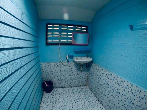 a blue bathroom with a sink and a window at DAYA Beach, Lipe local in Ko Lipe