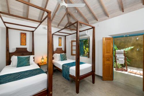 a bedroom with two beds and a window at STUTHI VILLA in Ahangama