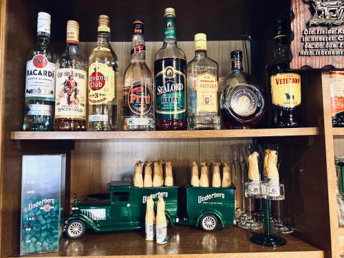 a toy truck sitting on a shelf with bottles of alcohol at Hotel Auerhahn in Grevenkrug